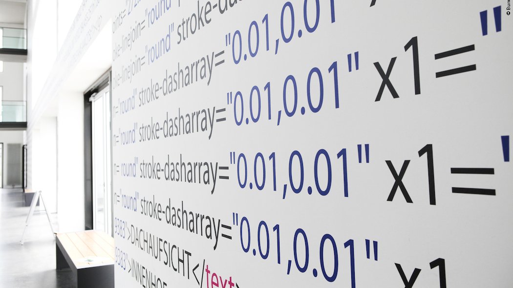 In einem öffentlichen Gebäude zeigt die Nahaufnahme einer Wand eine komplexe Formel mit Buchstaben und Zahlen.
