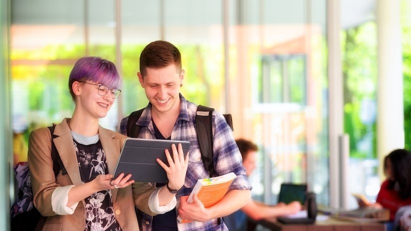 Eine Studentin und ein Student lernen in einer Universitätsbibliothek.