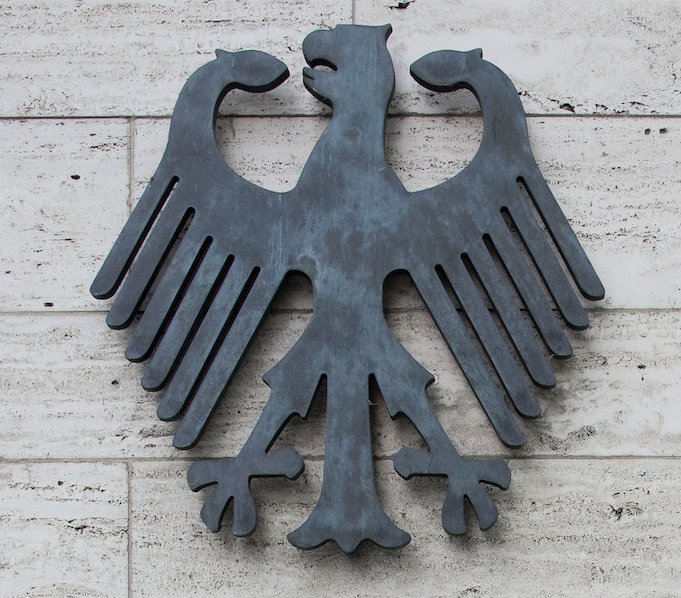 Nahaufnahme eines Bundesadlers an einer gefliesten Wand.