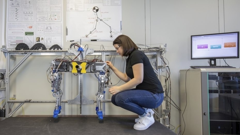 Eine junge Frau nimmt Einstellungen an einem Roboter vor.