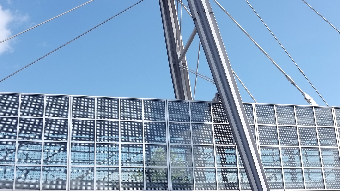 Zu sehen ist eine Stahlbrücke zwischen zwei Gebäuden.