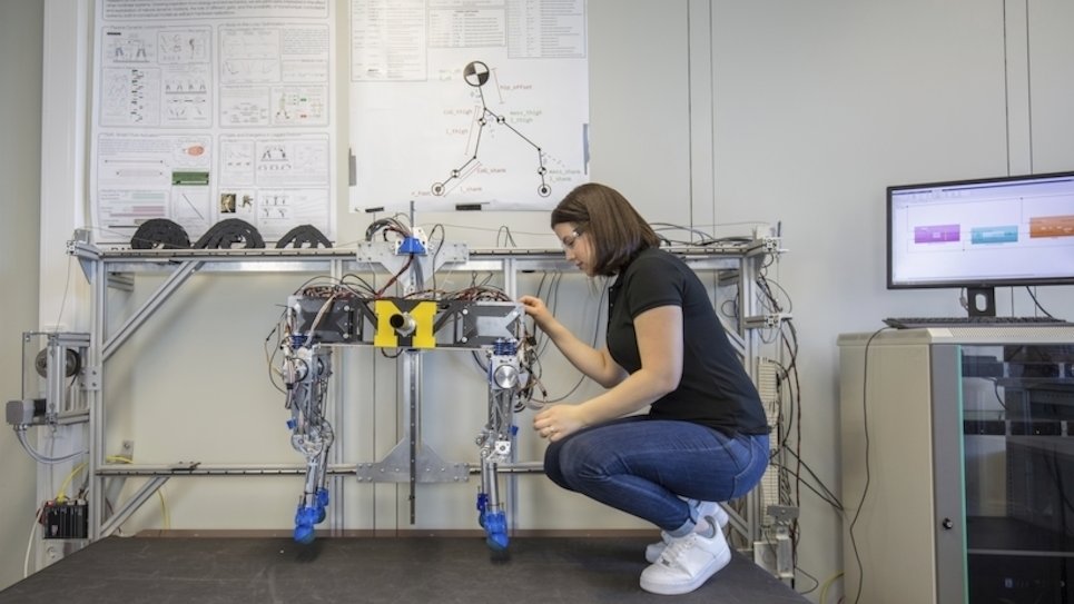 Eine junge Frau nimmt Einstellungen an einem Roboter vor.
