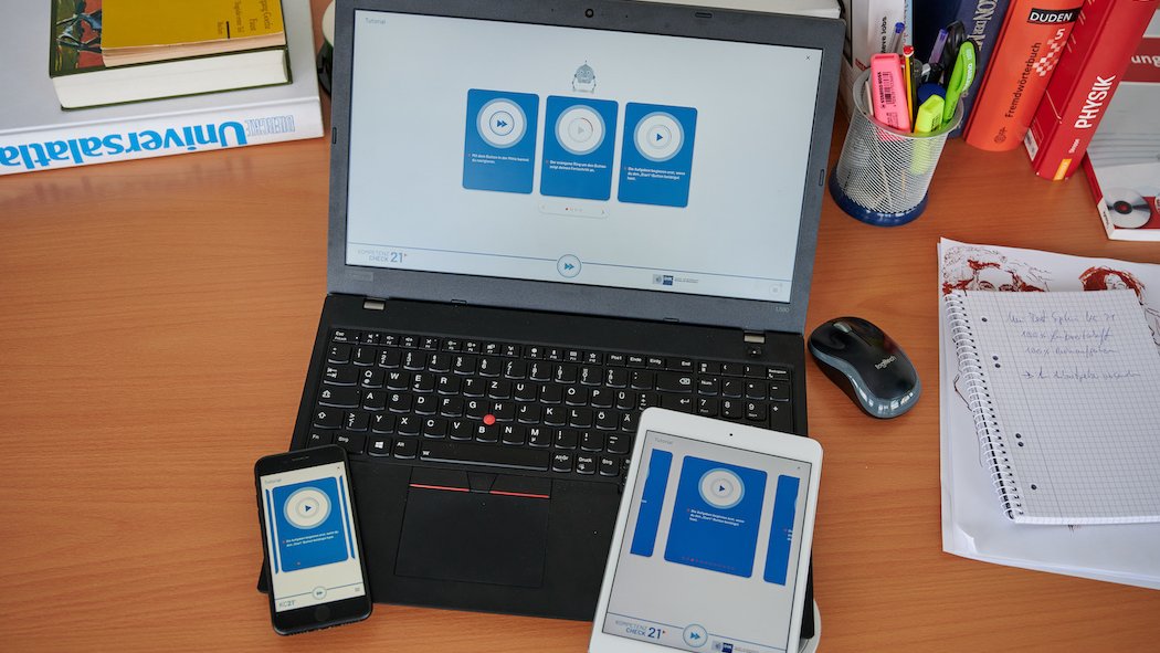 Die Bildschirme eines Laptops, eines Tablets und eines Smartphones zeigen einen Kompetenztest.