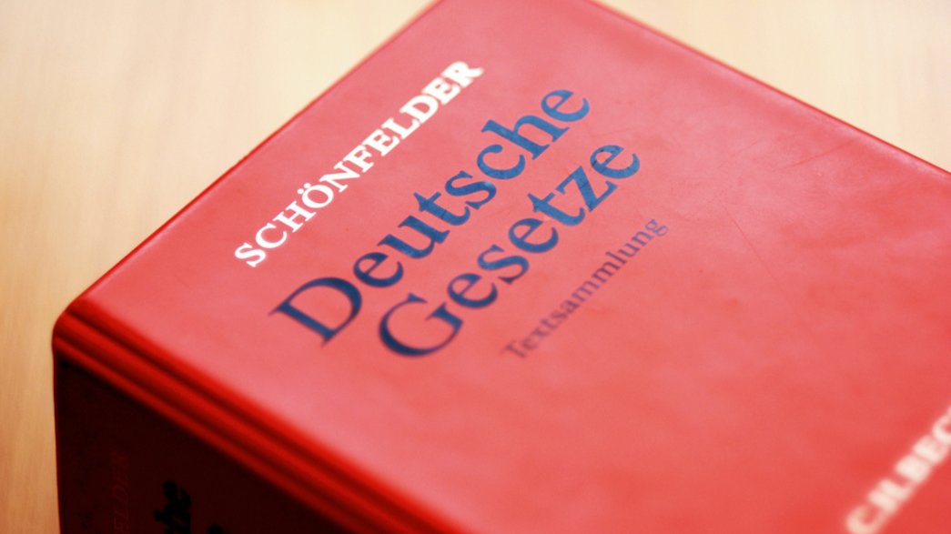 Teilaufnahme eines roten Plastikordners einer Loseblattsammlung mit der Aufschrift Deutsche Gesetze - Textsammlung.