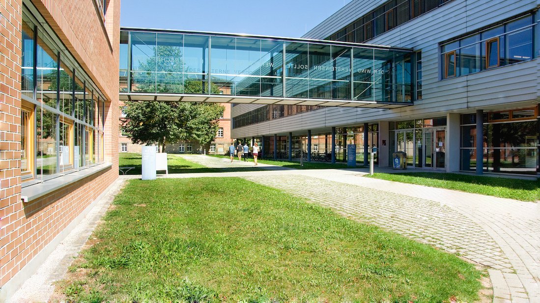 Zwei Gebäude der Hochschule Ansbach sind durch eine gläserne Brücke verbunden.