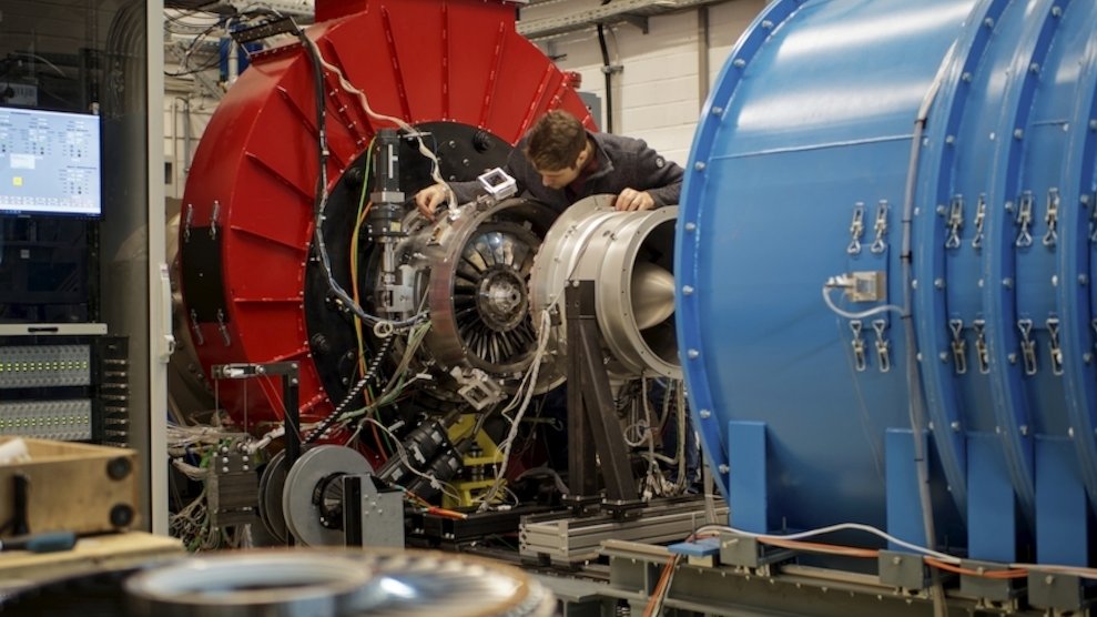 Ein junger Ingenieur schraubt an einer Gasturbine.