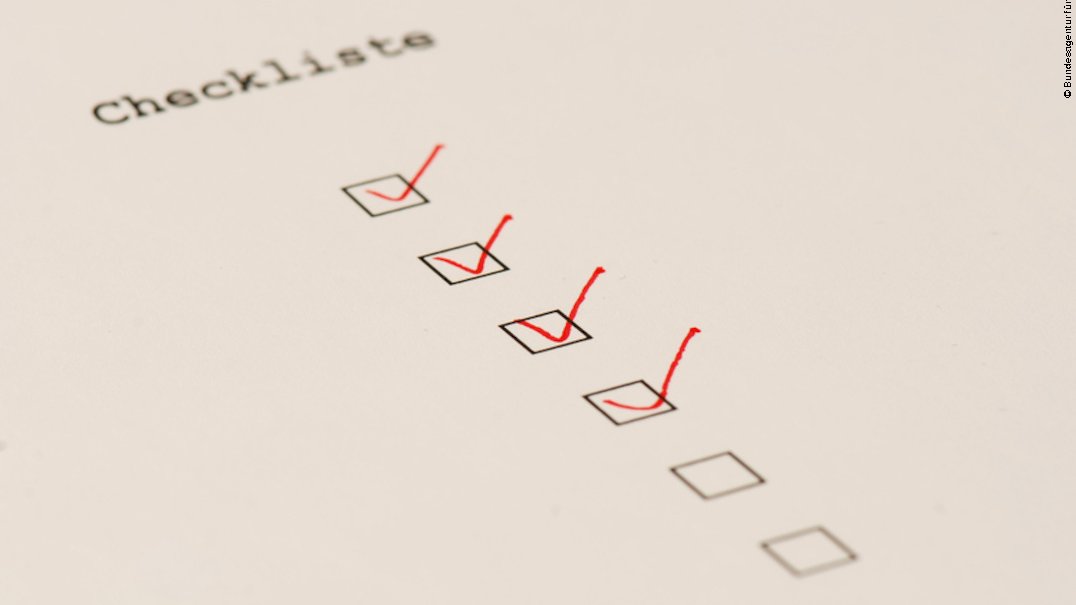 Detailaufnahme einer Checkliste mit sechs schwarzen Kästchen untereinander. Die vier oberen Kästchen wurden mit einem roten Stift angehakt.