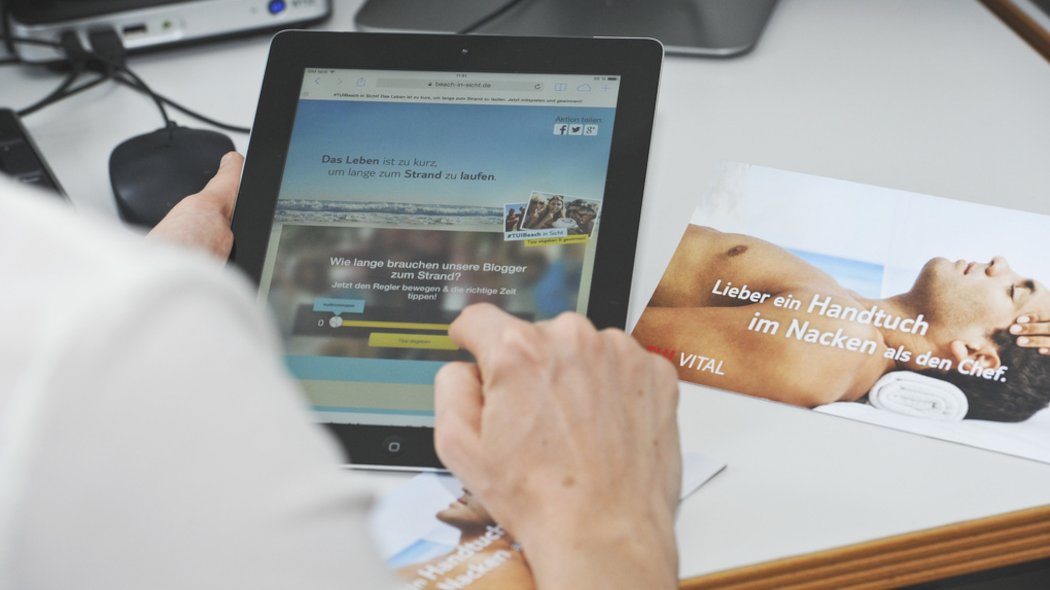 Ein Mann hat ein Tablet in der Hand.
