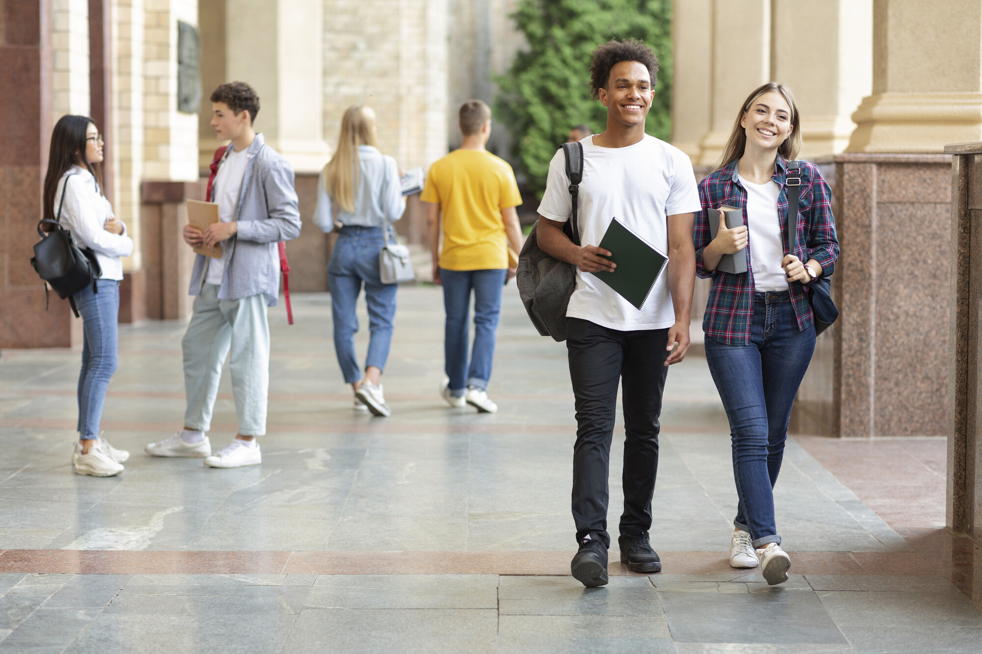  Gut gelaunte Studierende laufen auf dem Campus 