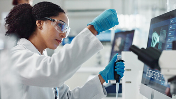 Wissenschaftlerin arbeitet im Labor für medizinische Studien mit Schutzkleidung.